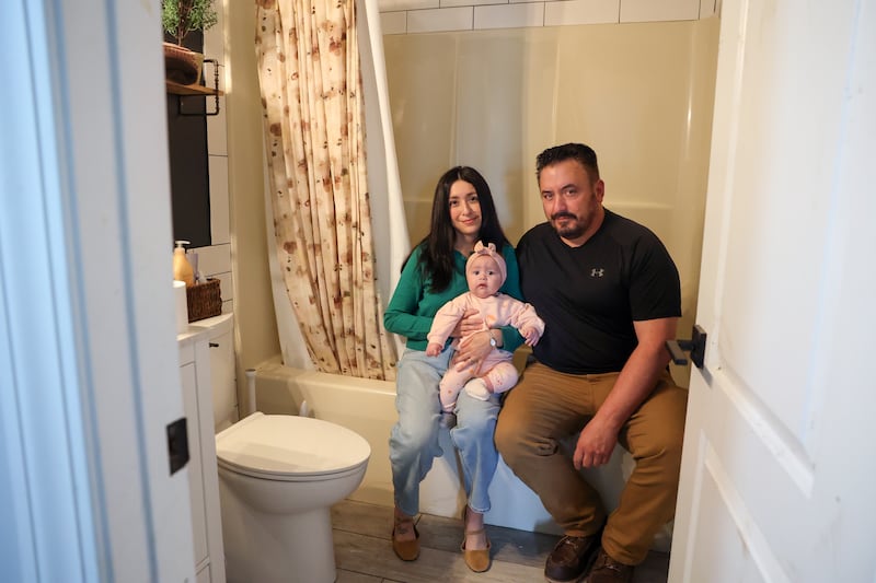 Anabel and Jimmy Horchem hold their 5-month-old daughter, Amelia, in the bathroom of their Aroma Township home on May 6, 2026, where they sheltered together over Amelia during the March 10 tornado that heavily impacted their home. The couple shared that for a moment, they didn't think they were going to survive the storm and prayed for their daughter to be saved.