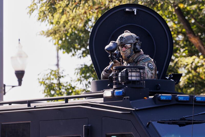 A federal officer stands guard in the Brighton Park neighborhood of Chicago, on Saturday, Oct. 4, 2025, after protesters learned that U.S. Border Patrol shot a woman Saturday morning on Chicago's Southwest Side. (Anthony Vazquez/Chicago Sun-Times via AP)