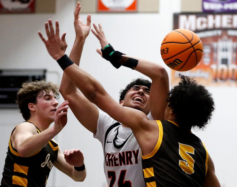 McHenry's Adam Anwar looses the ball as he is guarded by Jacobs' Ben Jurzak (left) and Jordan O'connor (right) during an IHSA Class 4A McHenry Regional basketball game on Wednesday, Feb. 26, 2025, at McHenry High School.