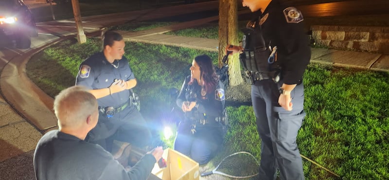 Geneva Officers Kaley Smith (left) and Erica Bolger with resident Russ Roschman at the rescue of five baby ducks that fell into a stormwater drain in the 600 block of Cannon Drive.
