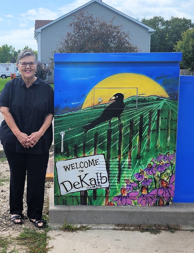 The utility box mural at the entrance to DeKalb High School on Dresser Road features the painting “Welcome to DeKalb, Illinois” by Christine Perkovich of DeKalb.