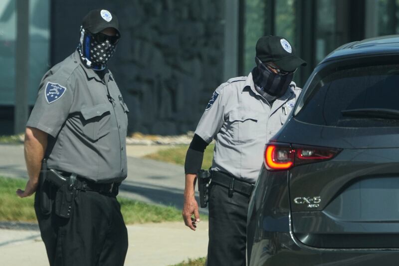 Federal agents (inside of a car) and security guards talk to each other outside of an ICE (U.S. Immigration and Customs Enforcement) processing facility in the Chicago suburb of Broadview, Ill., Wednesday, Sept. 17, 2025. (AP Photo/Nam Y. Huh)