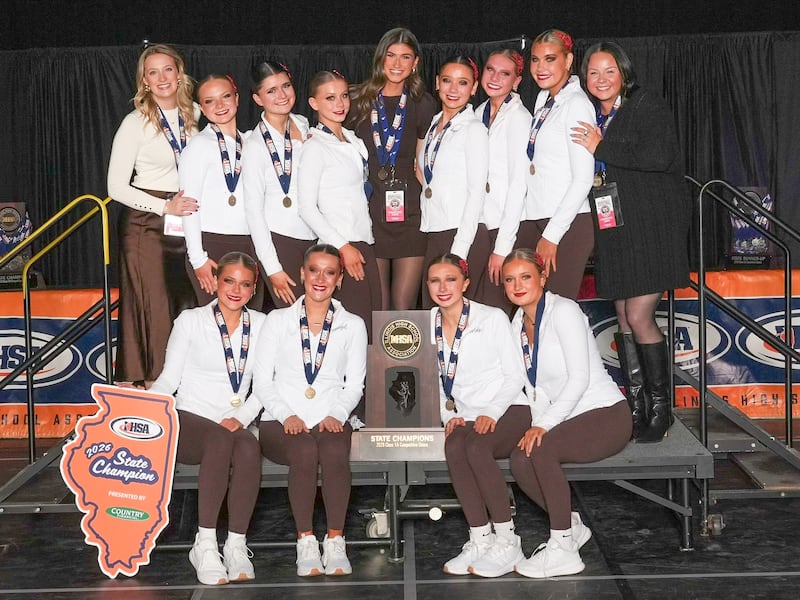 The Joliet Catholic Academy competitive dance team poses with its freshly won IHSA Class 1A state championship Saturday, Jan. 31, 2026, at Grossinger Motors Arena in Bloomington. The Angels finished Saturday's state finals with a winning score of 92.28, more than half a point better than runner-up Jacksonville’s score of 91.62. The state championship squad includes (left to right): seated in front - Ella Fredrickson, Calleigh Kubinski, Addysen Kirby and Olivia Ciemny; and standing in back – assistant coach Carsyn Whisenant, Rylie Kassel, Avery Quinn, Evelyn Borgra, head coach Ava Tomich, Anya Hrechko, Isabella Wieher, Haley Grant and assistant coach Abi Voss.