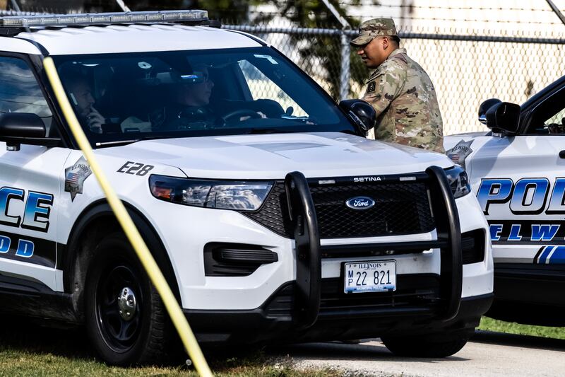 A soldier fist speaks to the driver of an Elwood Police vehicle at the Joliet Local Training Area site for the Illinois National Guard at 20612 Arsenal Road in Elwood on Wednesday, Oct. 8, 2025.