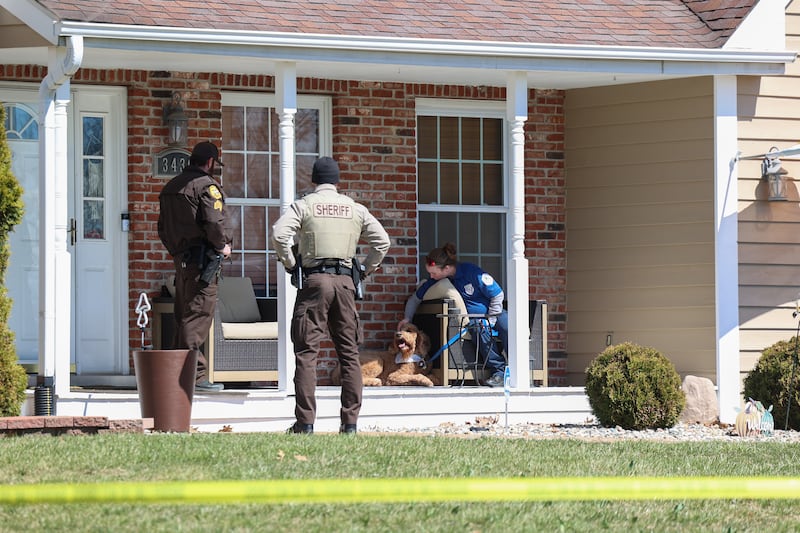 A Will County Animal Protection Services staff member comforts a pet dog as they help retrieve it from a home in the 3400 block of Norway Trail in Crete Township as the Will County Sheriff's Department investigates a triple homicide on Monday, March 23, 2026.