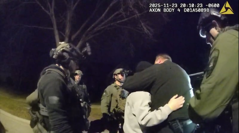 A crisis negotiator hugs Ryan Harter in November after the off-duty Downers Grove police officer surrenders, ending a four-hour armed standoff outside his Plainfield home.