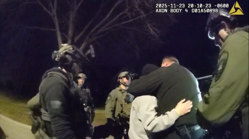 A crisis negotiator hugs Ryan Harter in November after the off-duty Downers Grove police officer surrenders, ending a four-hour armed standoff outside his Plainfield home.