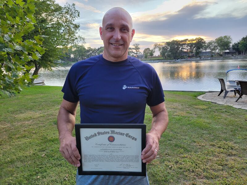 Shannon Anderson, superintendent of Momence School District, holds a certificate of commendation from his service in the United States Marine Corps outside of his home in Kankakee.