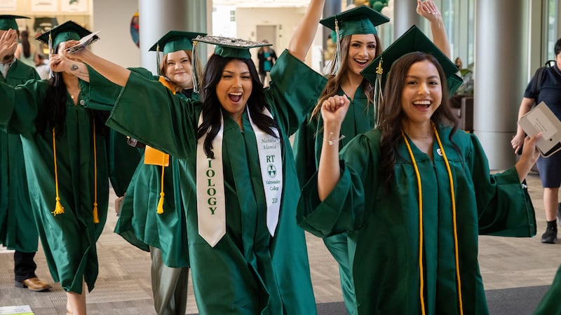 A group of Kishwaukee College graduates cheer as they walk to their seats to begin the commencement ceremony on Saturday, May 16, 2026, at the college's Malta campus.