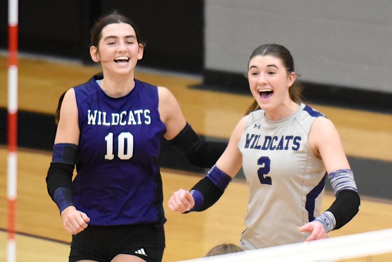 Wilmington's Rachel Smith, left, and Sami Liaromatis celebrate a Wildcats point during a game at Manteno Tuesday, Oct. 7, 2025.