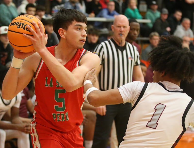 L-P's Erick Sotelo looks to pass the ball around Peoria's Spencer Russell during the Class 3A Sectional semifinal game on Wednesday, March 5, 2025 at Washington High School.