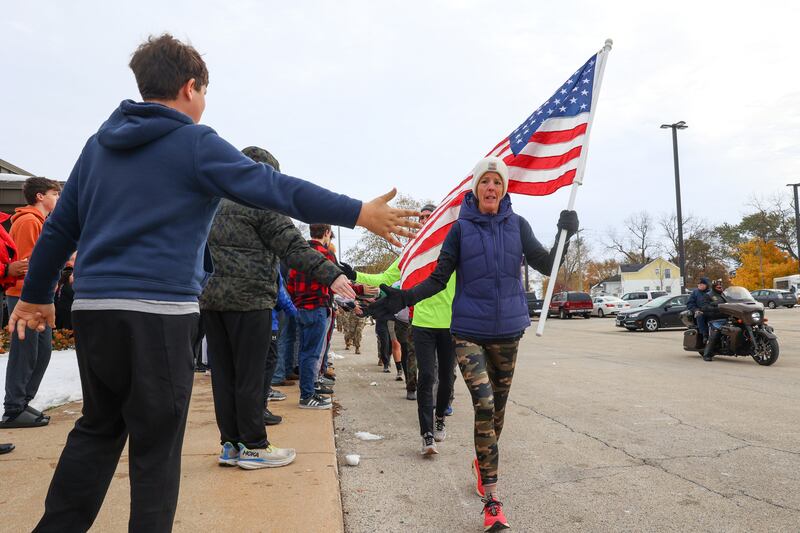 Jen Ingram, a U.S. Navy veteran of Donovan, and the superintendent of the Iroquois County Veterans Assistance Commission, joins fellow military members in receiving high fives from Manteno High School students during the 11th Manteno Veterans Run on Tuesday, Nov. 11, 2025.