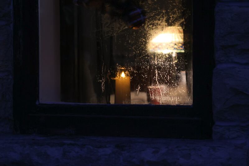 A candle sits in the window of the small parlor room of the Allen House, where many have reported seeing ghostly figures standing, on Saturday, Oct. 7, 2023 in Joliet