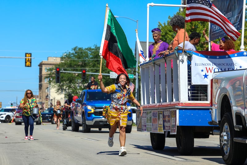 Charlene Eads, a Kankakee County Board candidate of Bradley, carries the Pan-African flag, also known as the Black Liberation flag, while running along East Court Street during the Juneteenth Celebration parade on Saturday, June 20, 2026, in Kankakee.