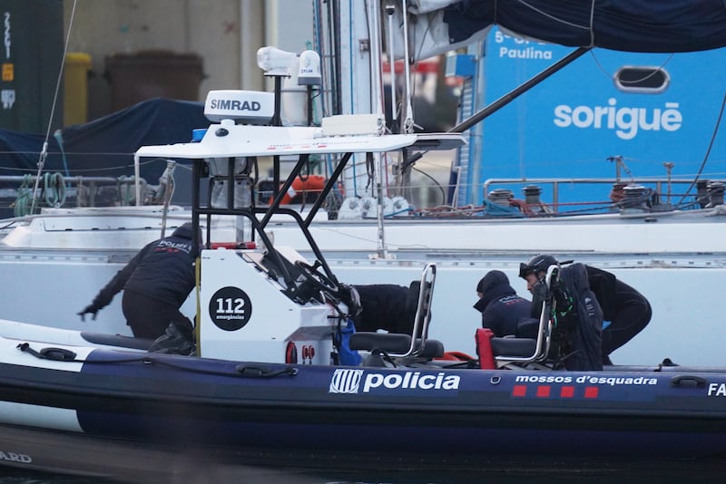 Police officers recover the body of a person found in the waters off the Port of Barcelona, Spain, on Thursday, March 19, 2026.