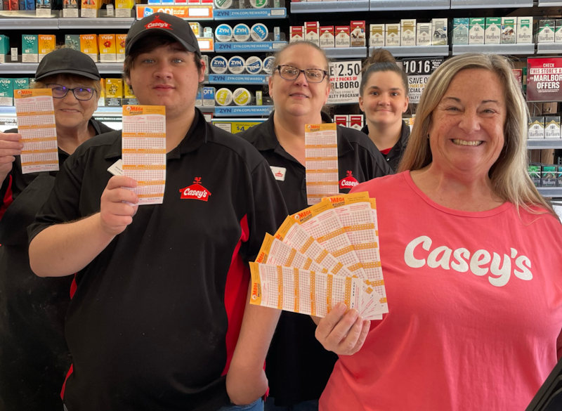 Casey’s district manager, Kim Shaw (right), takes a celebratory photo with her staff after selling a winning Mega Millions jackpot ticket worth a whopping $349 million.