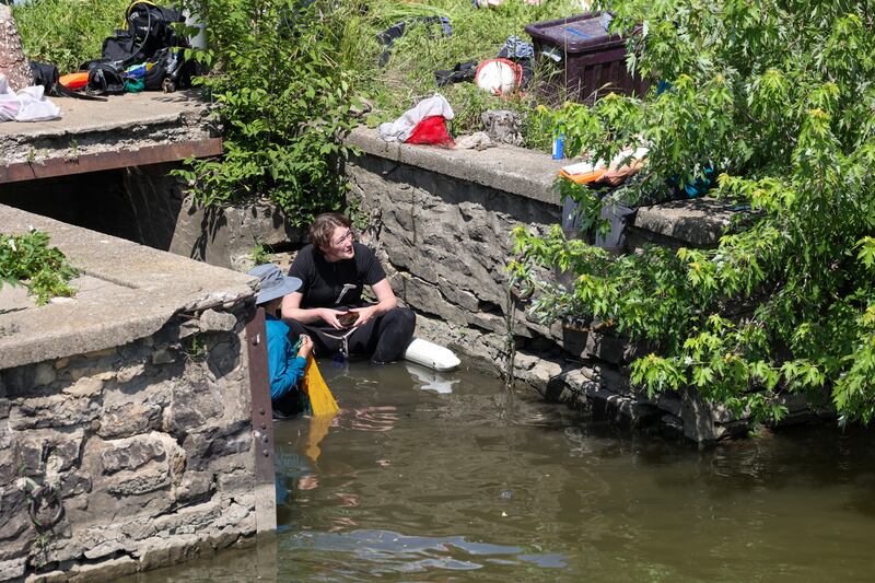Beth Hollinden, a malacologist with GZA GeoEnvironmental, communicates with her crew at the site of the East Riverwalk in Kankakee on Tuesday, June 24, 2025, where the search for the endangered river mussels is underway on Tuesday, June 24, 2025.