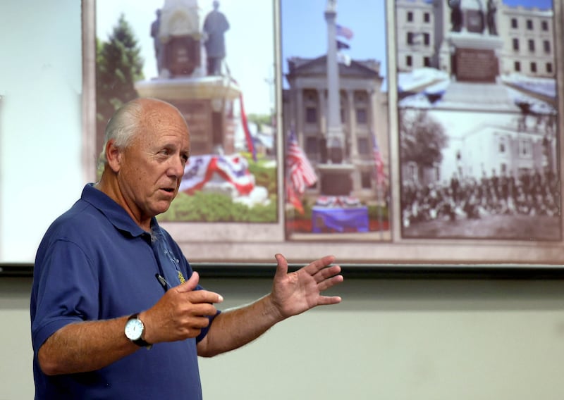 Dennis Maher, from the Sons of Union Veterans of the Civil War, talks about the DeKalb County Soldiers and Sailors Monument, shown on the screen, Thursday, Sept 11, 2025, during his presentation “Courthouse Guards” at the DeKalb County History Cener in Sycamore. The Soldiers and Sailors monument stands in front of the DeKalb County Courthouse in Sycamore.
