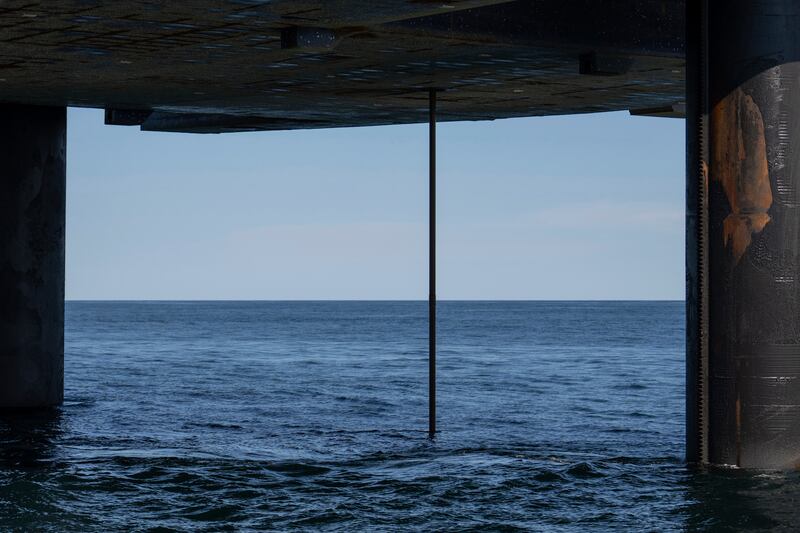 The wireline drilling core barrel is visible from the underside of the Liftboat Robert platform, from the Gaspee, a crew transport vessel, in the North Atlantic, Saturday, July 19, 2025. (AP Photo/Carolyn Kaster)