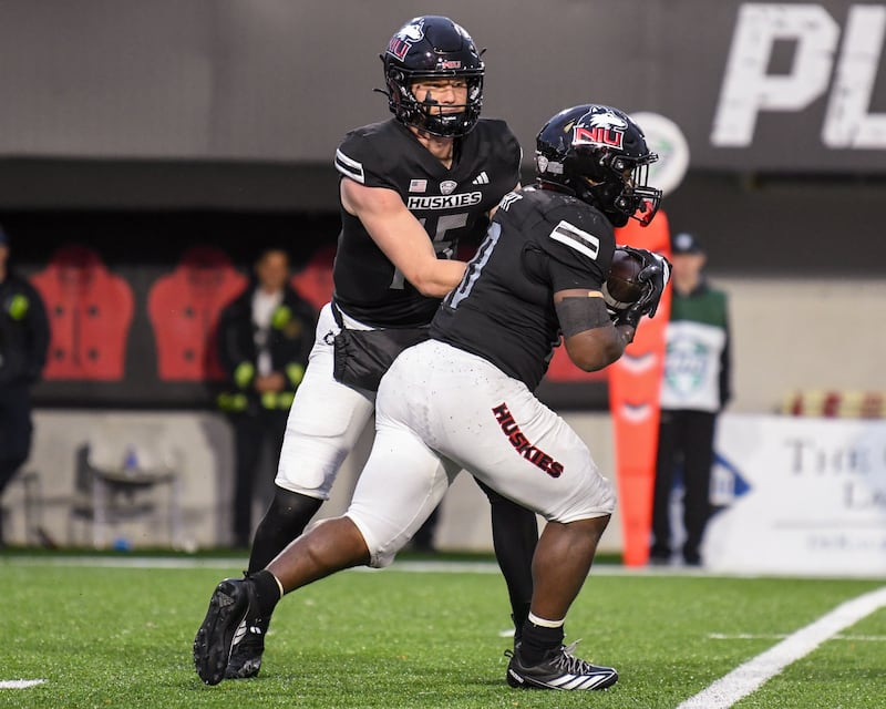 Northern Illinois University's quarterback Josh Holst (15) hands the ball off to teammate running back Chavon Wright (10) during the game on Saturday Oct. 25, 2025, held at Huskie Stadium in DeKalb.