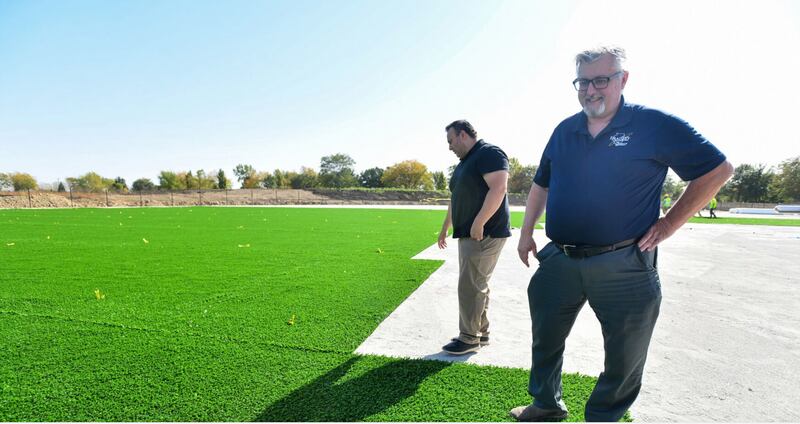 Bradley Mayor Mike Watson, right, along with finance director Rob Romo, stand on some of the first turf installed at the new Bradley sports complex project in October. The 12-diamond complex is just one of the developments Bradley is investing in as growing cash reserves fuel developments.