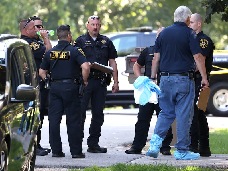 DeKalb County sheriff’s deputies and other investigators talk Tuesday, Sept. 30, 2025, in the driveway of a house in the 1300 block of Oakland Drive in Sycamore where two people were found dead Tuesday morning.