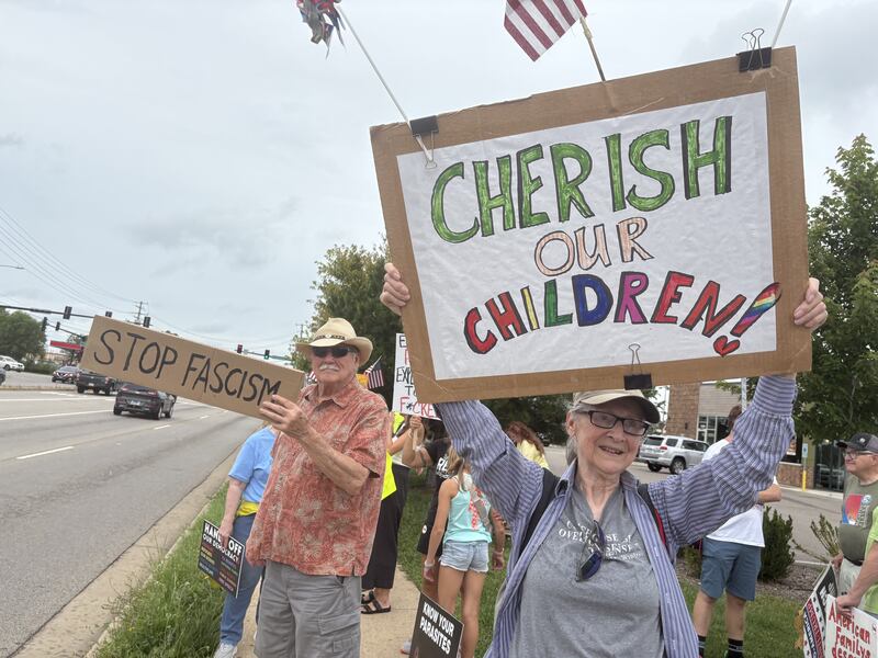 Protesters hold up signs during a protest in McHenry July 26, 2025.