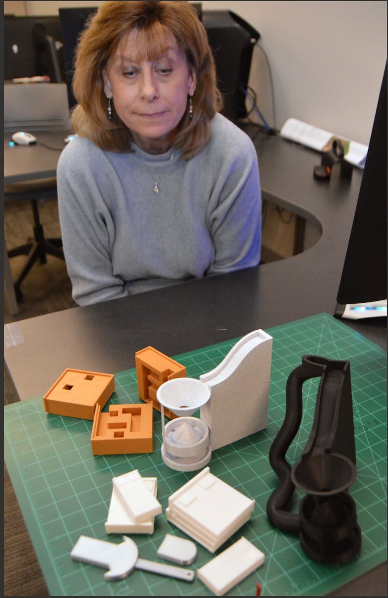2026 MIMIC projects begin as drawings, then progress to 3D prototypes like those arrayed in front of instructor Mary Smith. The projects designed by IVCC CAD students will be displayed and sold at the annual MIMIC festival April 24 in the Student Life Space.