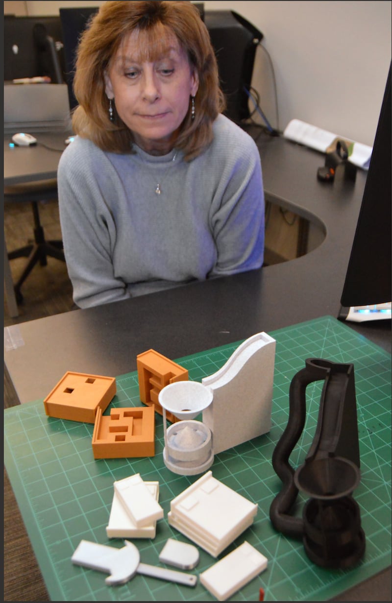 2026 MIMIC projects begin as drawings, then progress to 3D prototypes like those arrayed in front of instructor Mary Smith. The projects designed by IVCC CAD students will be displayed and sold at the annual MIMIC festival April 24 in the Student Life Space.