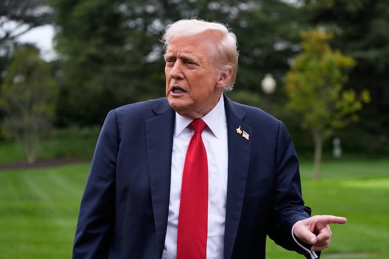 President Donald Trump speaks with reporters as he walks from Marine One after arriving on the South Lawn of the White House, Tuesday, Sept. 30, 2025, in Washington. (AP Photo/Alex Brandon)
