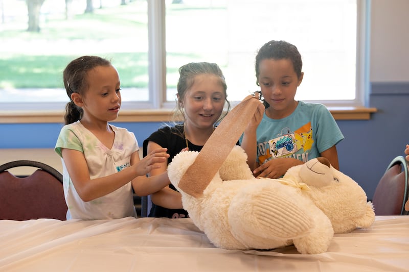 Kendra (left), Raegan and Bridget work together to wrap up a Teddy bear with tape Monday, July 28, 2025, during a workshop on the life of a veterinarian hosted by the University of Illinois Extension and the Whiteside 4-H club at the Rock Falls Library.