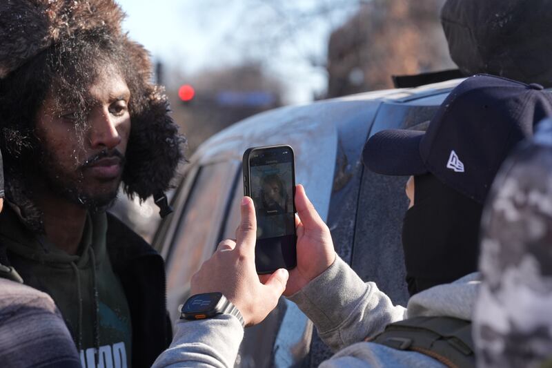 ADDS REFERENCE TO FACIAL RECOGNITION APP -  Federal agents use a facial recognition app on a person detained and who later released on Tuesday, Jan. 27, 2026, in Minneapolis. (AP Photo/Adam Gray)