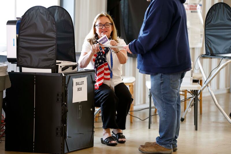 Election Jude Liz Albert of Wheaton helps people cast their votes after they finish their ballots at the DuPage County Fairgrounds polling site Tuesday, April 1, 2025 in Wheaton Ill.