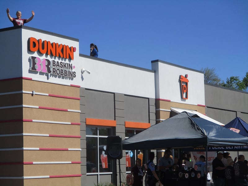 A Joliet police officer waves from the roof of the Dunkin' store at 3011 Plainfield Road in Joliet on Friday for the annual Cop on a Rooftop fundraiser for Special Olympics.