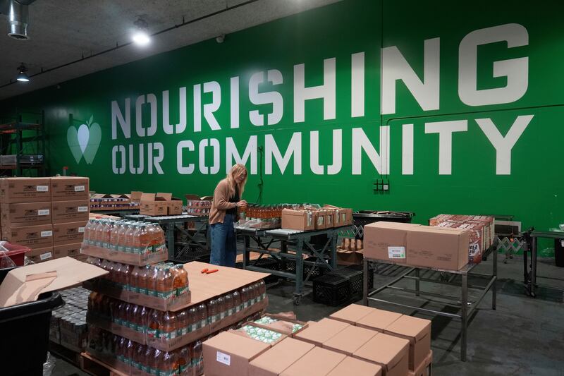 FILE - Mara Sleeter, marketing and communications project manager, stands near boxes of juice while being interviewed in the San Francisco-Marin Food Bank warehouse in San Francisco, July 2, 2025. (AP Photo/Jeff Chiu, File)