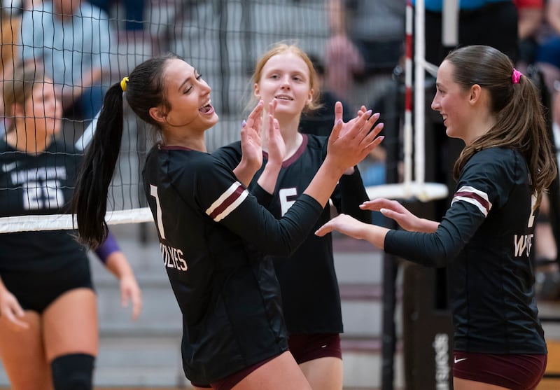 Prairie Ridge teammates Maizy Agnello, left to right, Sonora Bekere and Addi Smith celebrate after scoring a point during their game on Thursday, October 2, 2025 at Prairie Ridge High School in Crystal Lake. Ryan Rayburn for Shaw Local