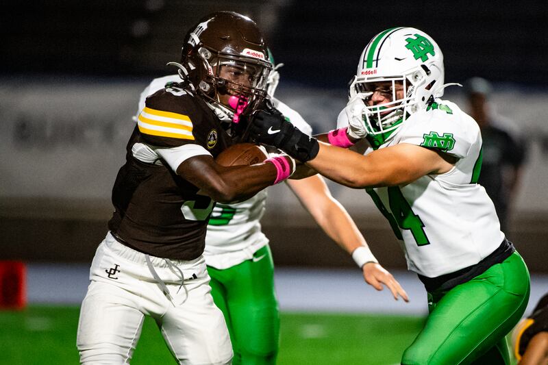Joliet Catholic Academy's Craig Peacock pushes off Niles Notre Dame's TJ Forbes during a game against on Friday Oct. 3, 2025 at Busey Bank Field in Joliet