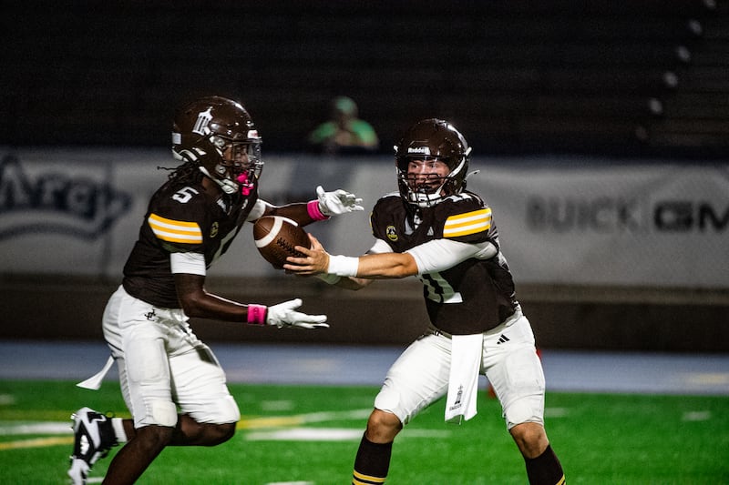 Joliet Catholic Academy's Lucas Simulick hands off the ball to Craig Peacock during a game against Niles Notre Dame on Friday Oct. 3, 2025 at Busey Bank Field in Joliet