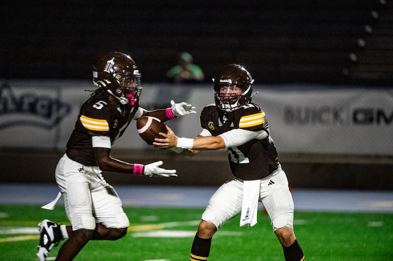 Joliet Catholic Academy's Lucas Simulick hands off the ball to Craig Peacock during a game against Niles Notre Dame on Friday Oct. 3, 2025 at Busey Bank Field in Joliet