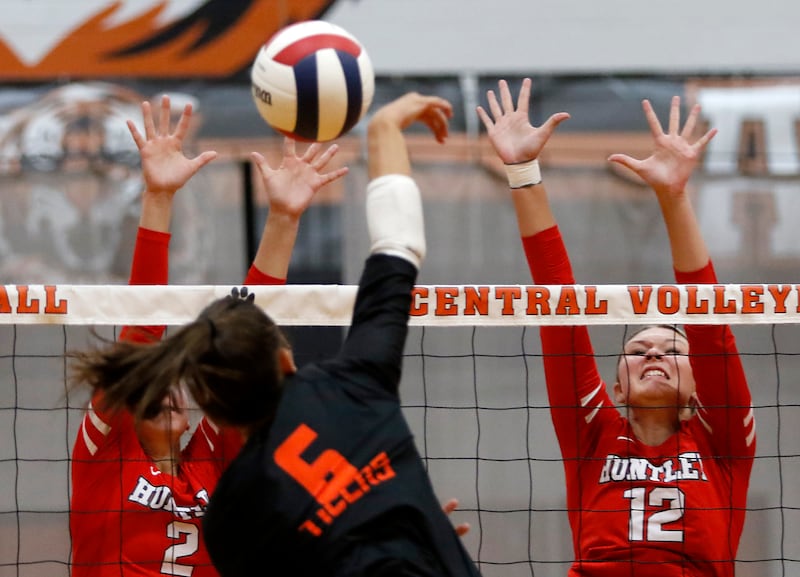 Crystal Lake Central's Clara Dobbertin (center) tries to het the ball through the block of Huntley's Rachael Hein (left) and Summer Massow (right) during a Fox Valley Conference volleyball match on Tuesday,Aug. 26, 2025, at Crystal Lake Central High School.