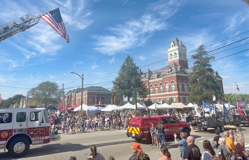 Sunny skies and hot temperatures greeted visitors to the Harvest Time Parade held during Autumn on Parade on Sunday, Oct. 5, 2025 in Oregon. Here, the Oregon Fire Department raises an American flag for the National Anthem in front of the parade viewing stand on S.. Fourth Street (state Route 2).
