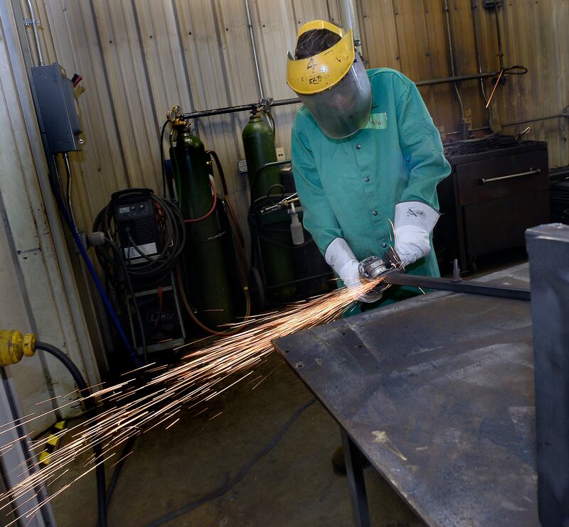 Declan Kulpa shaves down a leg for a side table Wednesday, July 28, 2023, during SPARK Junior Welding program, part of Illinois Valley Community College's summer camp program.