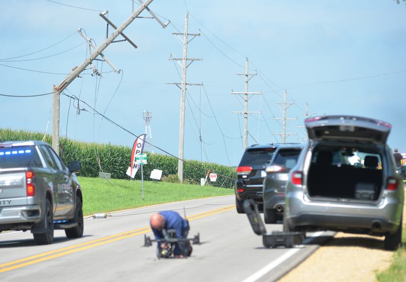 An Ogle County Sheriff Deputy works on getting the department's drone into the air following a single-plane accident near the Ogle County Airport between Oregon and Mt. Morris on Tuesday, July 22, 2025. The pilot of a crop-dusting plane was killed. after hitting power lines near the airport. A section of Illinois Route 64 was closed for ComEd crews to repair the damage.