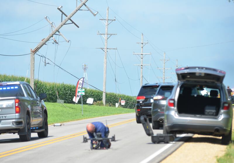 An Ogle County Sheriff Deputy works on getting the department's drone into the air following a single-plane accident near the Ogle County Airport between Oregon and Mt. Morris on Tuesday, July 22, 2025. The pilot of a crop-dusting plane was killed. after hitting power lines near the airport. A section of Illinois Route 64 was closed for ComEd crews to repair the damage.