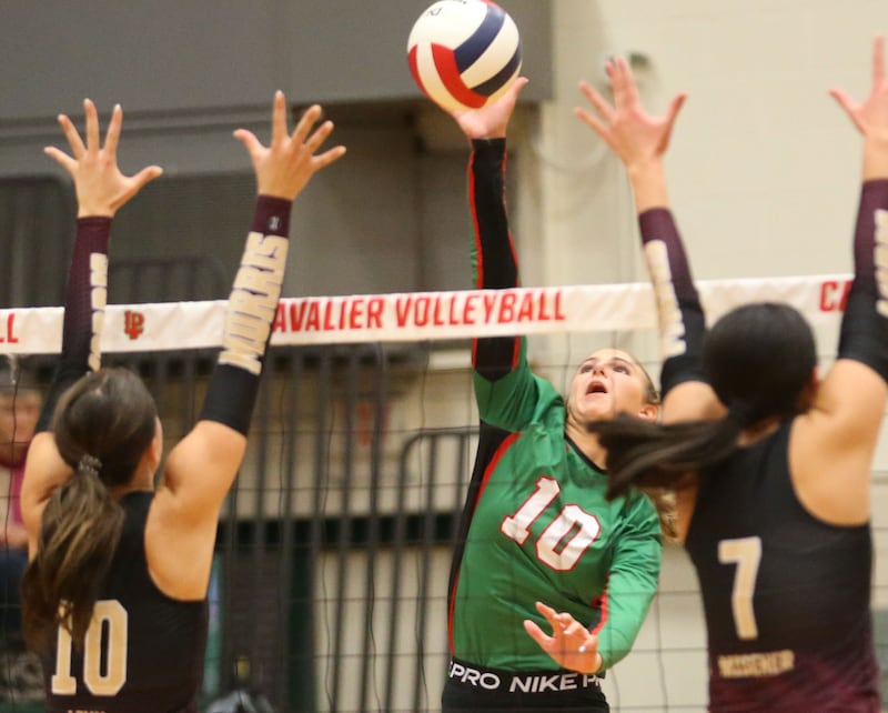 L-P's Kelsey Frederick sends a kill past Morris's Hannah Linn and tammate Rosemary Misener on Thursday, Oct. 10, 2024 in A.J. Sellett Gymnasium at L-P High School.