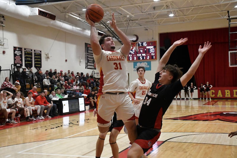 St. Anne's Brandon Schoth shoots a layup while being guarded by Momence's Jackson Ford during St. Anne's 61-46 victory over Momence on Tuesday December 9, 2025.