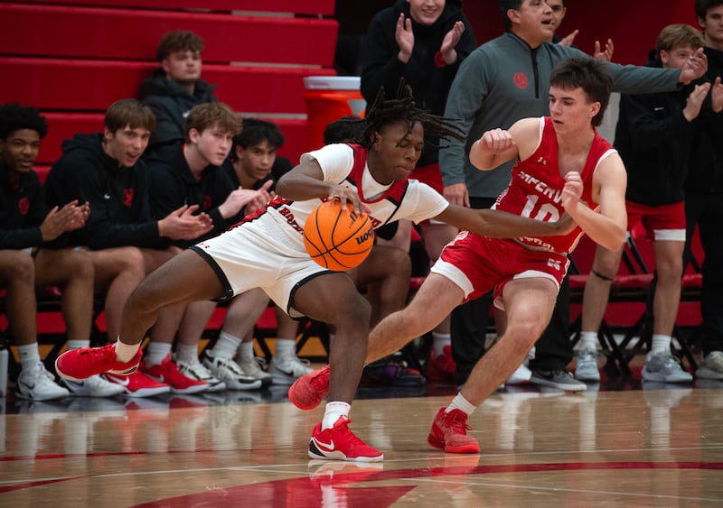Bradley-Bourbonnais's Kobe Lawrence, left, controls the ball as Naperville Central's Cooper Page, right, guards in a game on Monday, December 15, 2025.