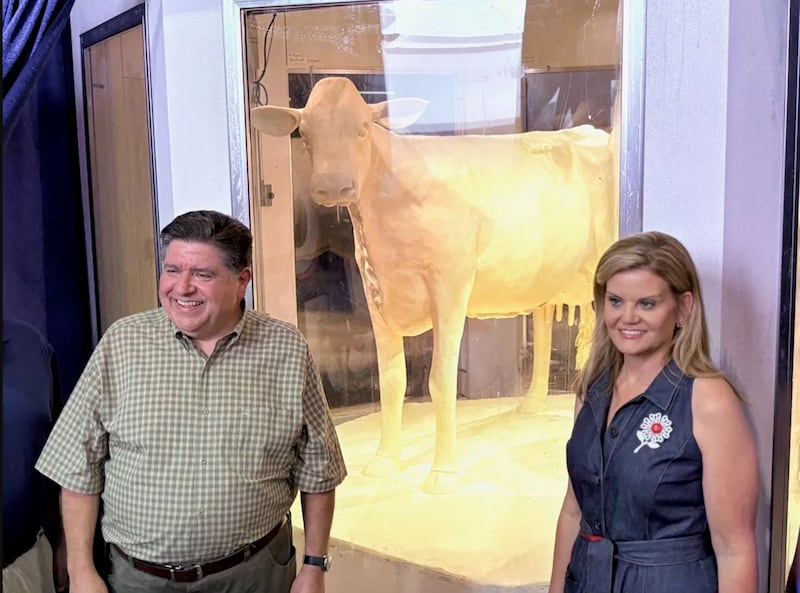 Governor JB Pritzker and wife MK pose for a photo with the 2025 butter cow.