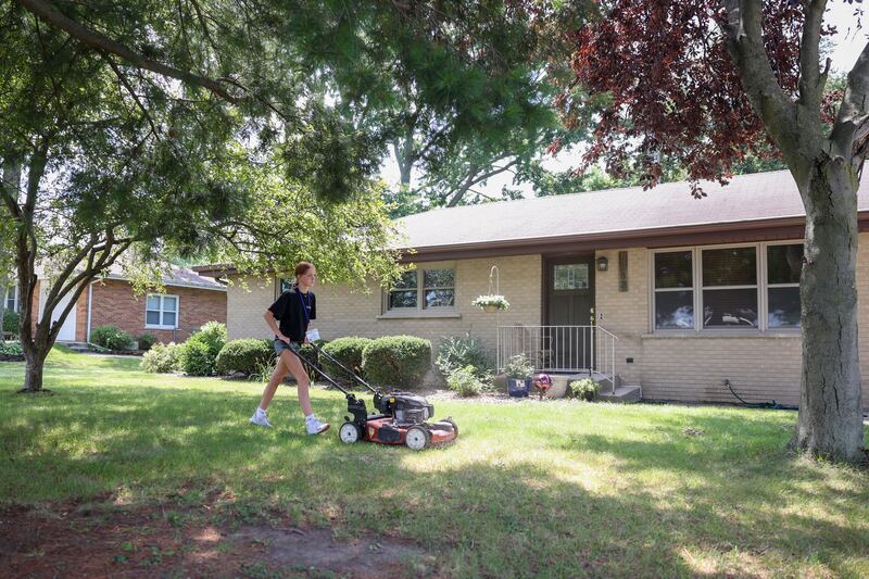 Aubrie Coughlan, 13, of Kankakee, mows the grass at a project site in Bourbonnais on July 22, 2025, during the 9th Camp MOSH, a week-long volunteer service camp from Maternity BVM parish. Coughlan, a soon-to-be 8th grader at Bishop McNamara, participated for the first time and said she found the work meaningful.