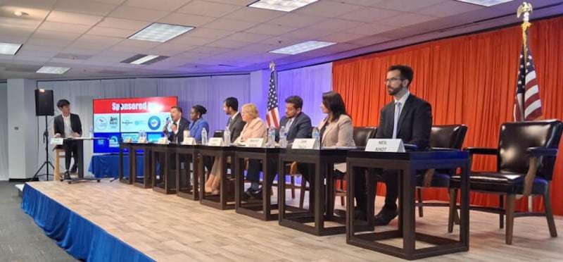 Moderator Ishaan Srivastava, far left, questions seven of the eight candidates in the Democratic primary for the 8th Congressional District Thursday at National India Hub. On the panel, from left, are Kevin Morrison, Yasmeen Bankole, Ryan Vetticad, Melissa Bean, Junaid Ahmed, Sanjyot Dunung and Dan Tully. Absent is Neil Khot.